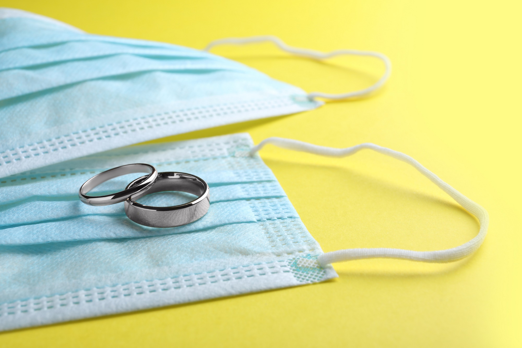Protective,Masks,And,Wedding,Rings,On,Yellow,Background.,Divorce,During